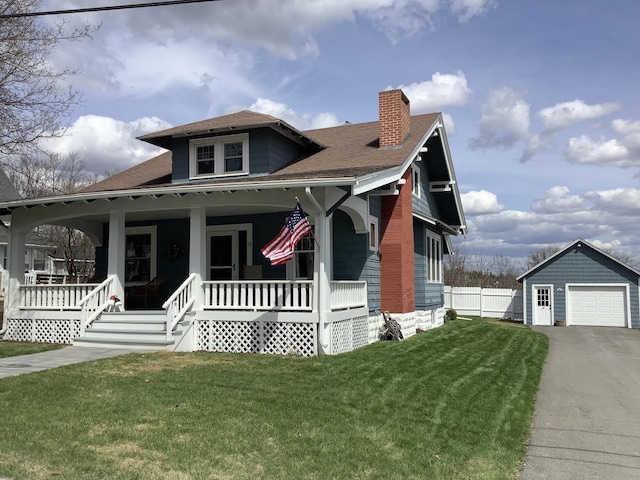 bungalow with a porch, fence, an outdoor structure, a front yard, and a chimney