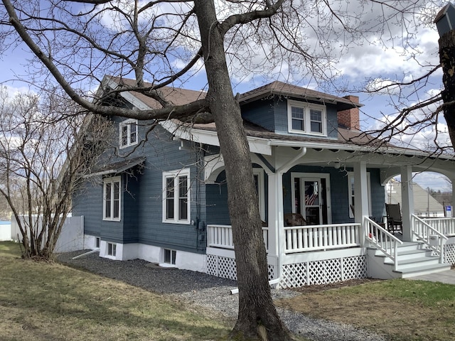 view of front of house with covered porch and a chimney