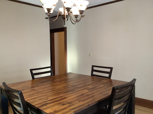 dining room with crown molding and a notable chandelier