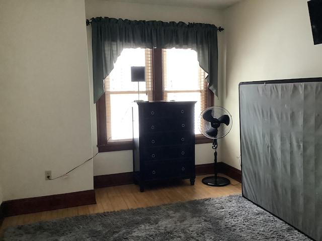 bedroom featuring baseboards and wood finished floors