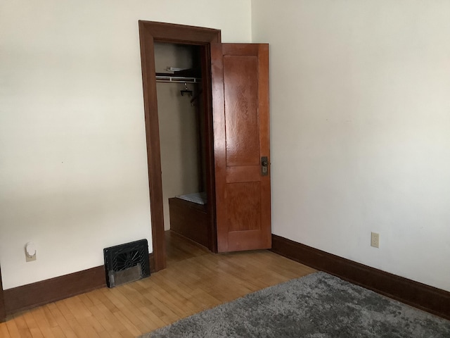 bedroom featuring a closet, baseboards, and wood finished floors