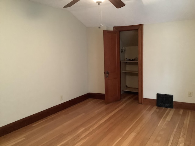 unfurnished bedroom with baseboards, light wood-style floors, and a spacious closet