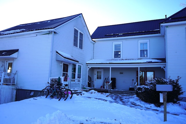 snow covered property featuring a porch