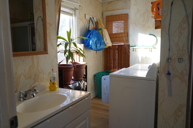 bathroom featuring sink, washer / clothes dryer, and wood-type flooring