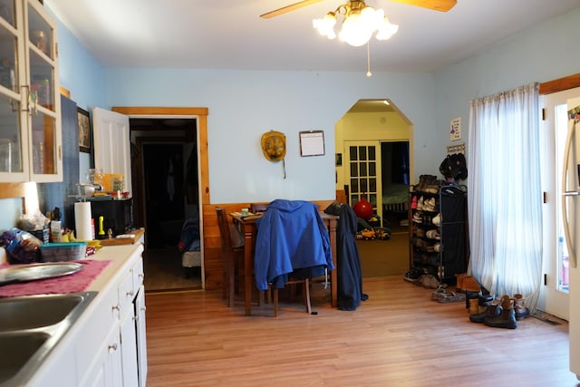 kitchen with ceiling fan, sink, white cabinetry, and light hardwood / wood-style flooring