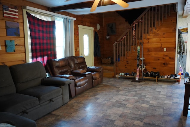 living room featuring wood walls, beam ceiling, and ceiling fan