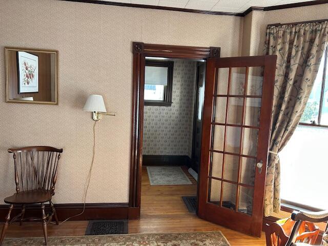 interior space with hardwood / wood-style flooring and ornamental molding