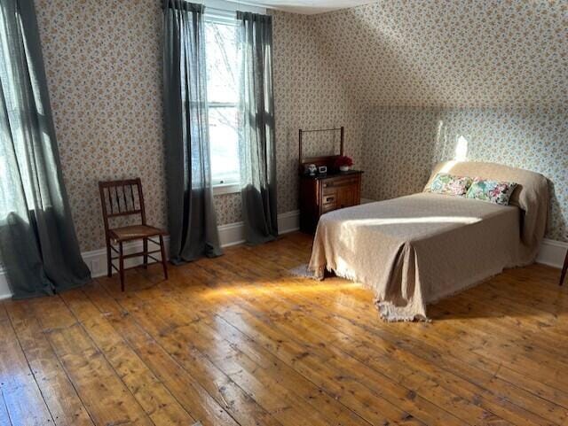 bedroom featuring multiple windows and dark wood-type flooring