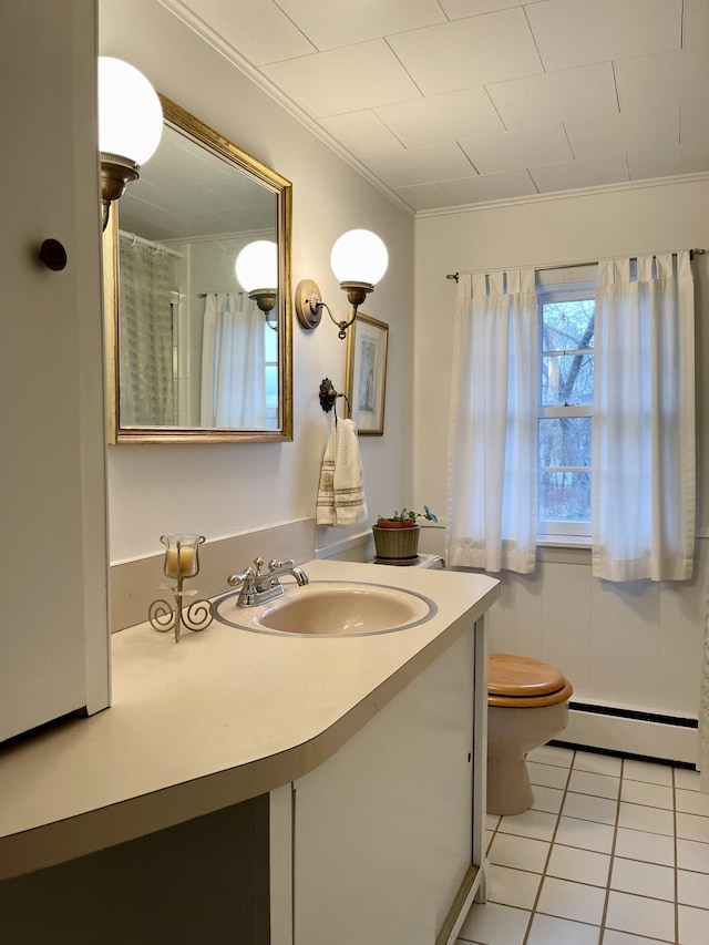 bathroom featuring baseboard heating, vanity, crown molding, and tile patterned flooring