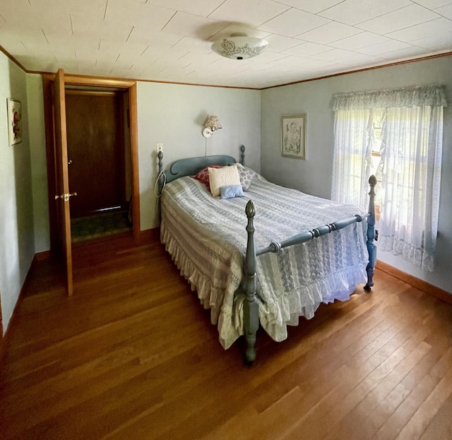 bedroom featuring wood-type flooring and ornamental molding