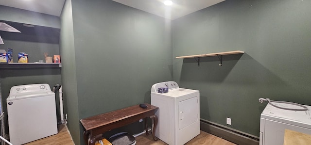 laundry room with washing machine and dryer and light hardwood / wood-style flooring