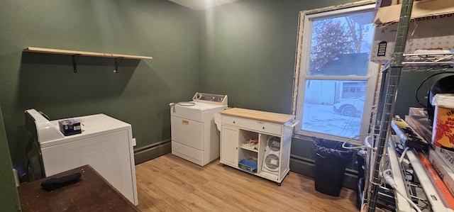 clothes washing area with light wood-type flooring and washer and clothes dryer