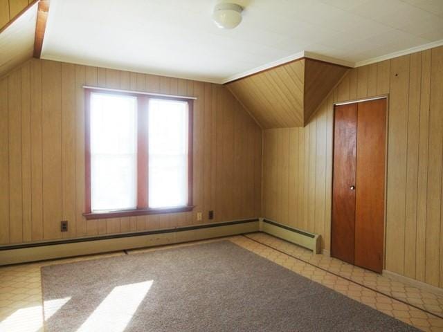 bonus room with a baseboard radiator, lofted ceiling, and wood walls