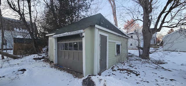 snow covered structure with a garage