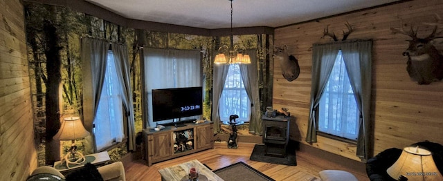 living room with wood-type flooring, wood walls, and a chandelier