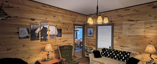 living room featuring an inviting chandelier and wooden walls