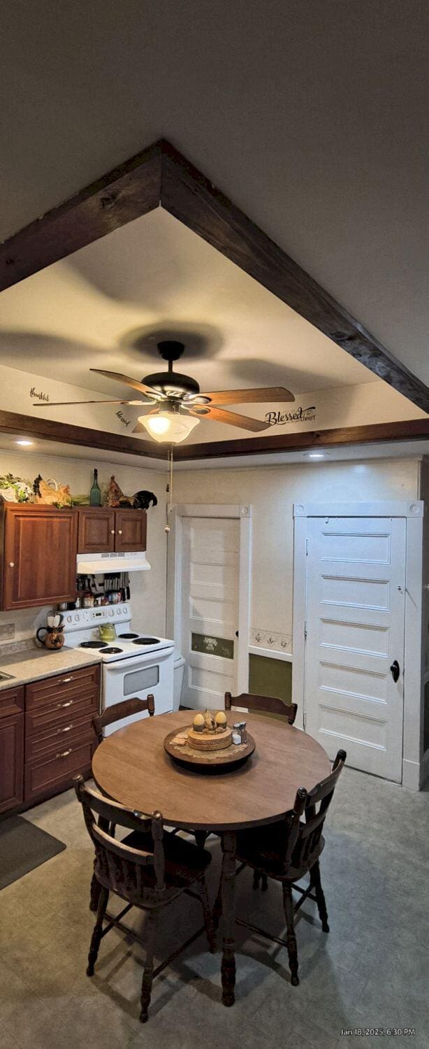 dining room with light carpet, beamed ceiling, and ceiling fan