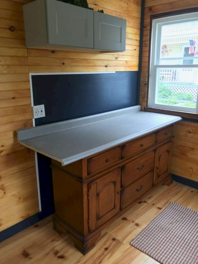 kitchen with light hardwood / wood-style floors and wooden walls