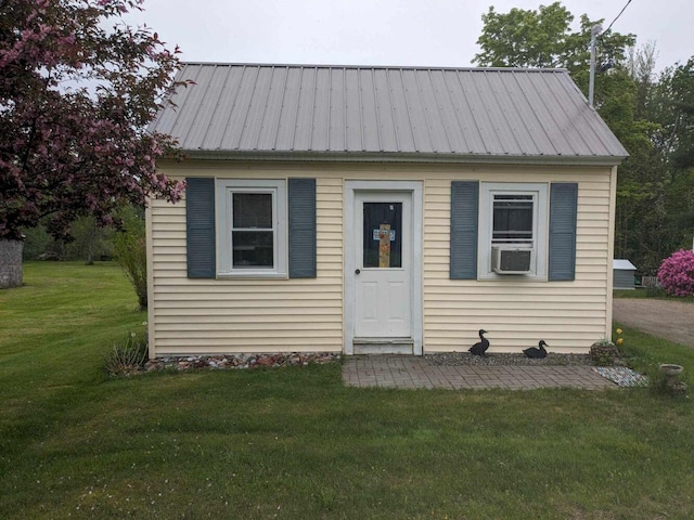 view of front of house featuring cooling unit and a front lawn