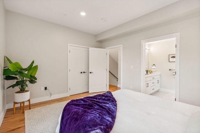 bedroom featuring light hardwood / wood-style floors and ensuite bath