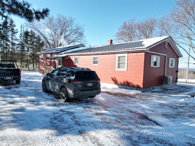 view of snow covered exterior with cooling unit