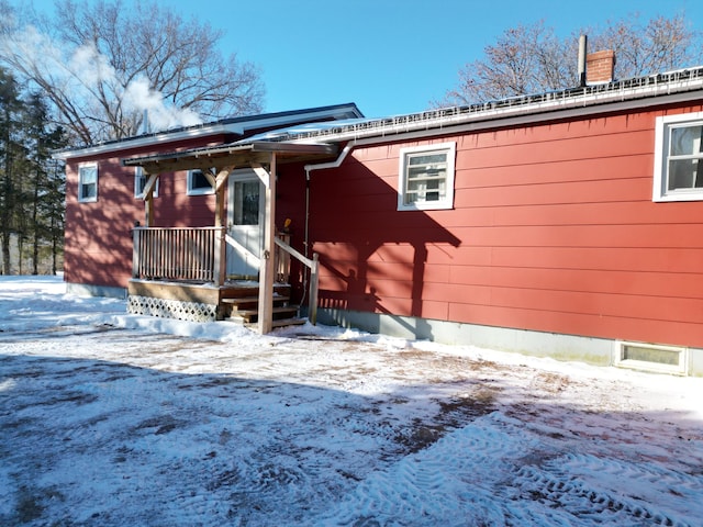 view of snow covered rear of property