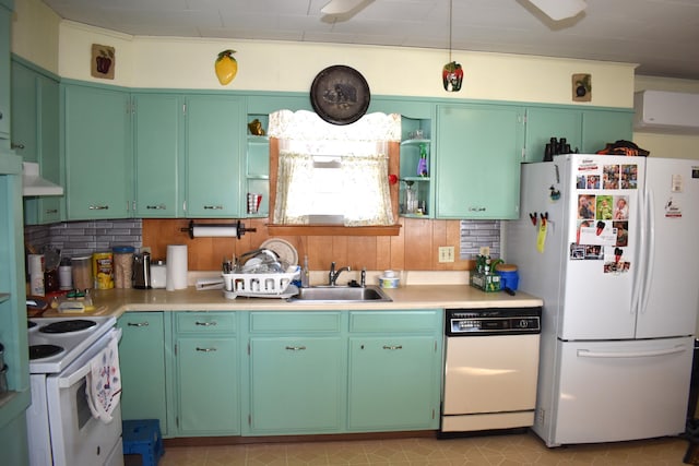 kitchen with sink, decorative backsplash, green cabinetry, wall chimney range hood, and white appliances