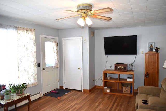 living room featuring a baseboard heating unit, hardwood / wood-style floors, and ceiling fan