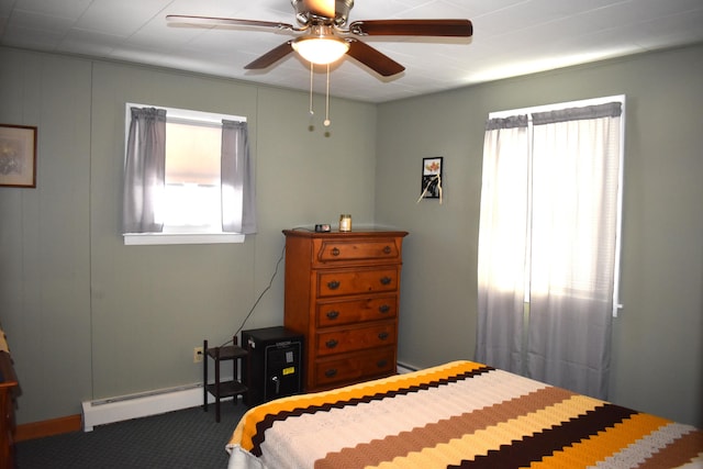 carpeted bedroom with a baseboard heating unit and ceiling fan