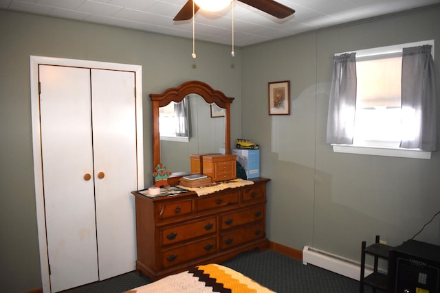 bedroom with ceiling fan, a baseboard radiator, and a closet