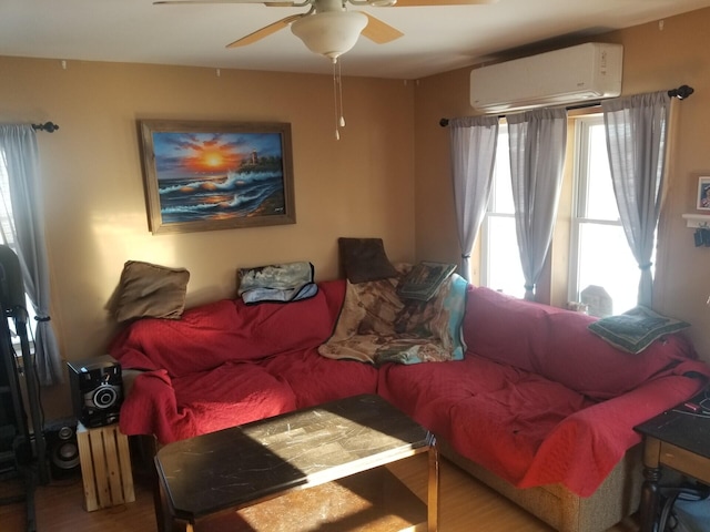 living room featuring wood-type flooring, a wall unit AC, and ceiling fan