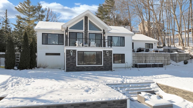 snow covered property with a balcony