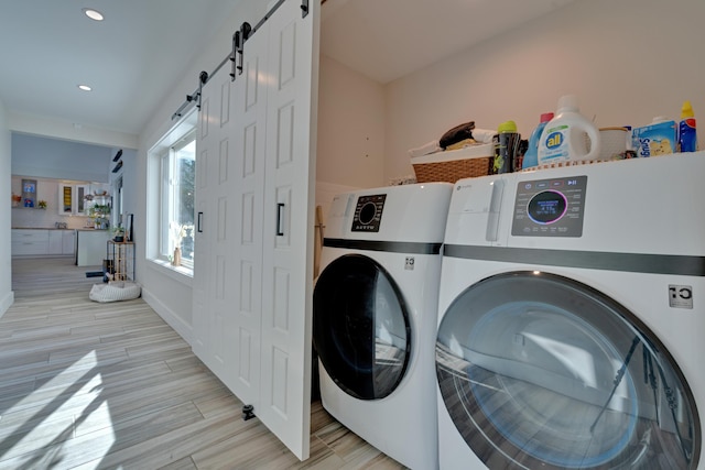 laundry room with separate washer and dryer and a barn door