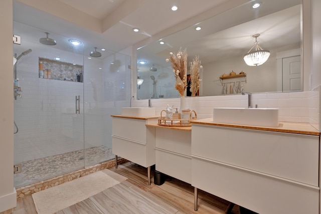 bathroom featuring hardwood / wood-style flooring, vanity, tasteful backsplash, and walk in shower
