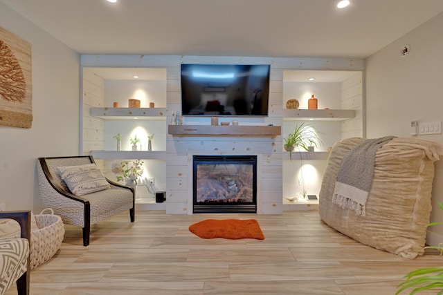 sitting room with a large fireplace and light wood-type flooring