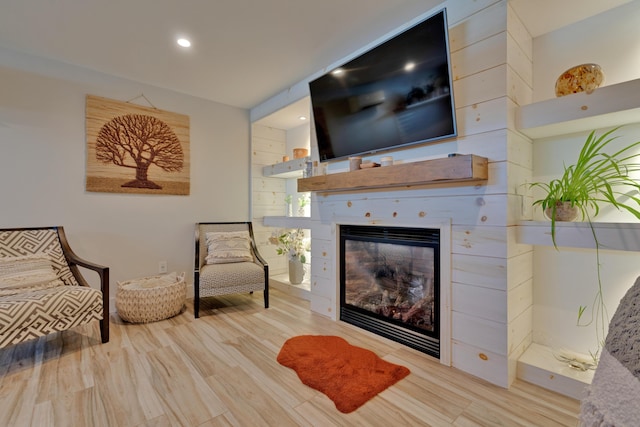 living area featuring light hardwood / wood-style flooring and a tile fireplace
