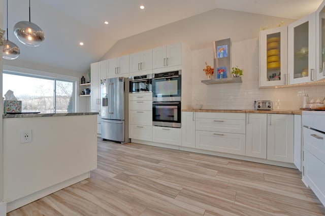 kitchen with pendant lighting, white cabinetry, stainless steel appliances, and lofted ceiling