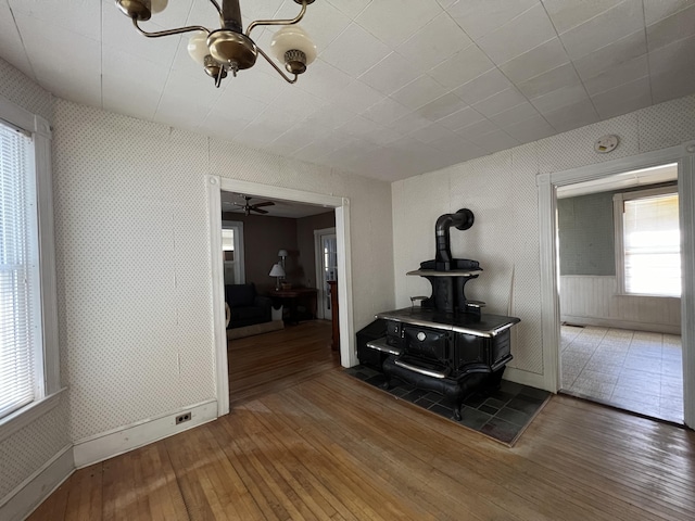 living room with a wood stove, a wealth of natural light, and hardwood / wood-style floors