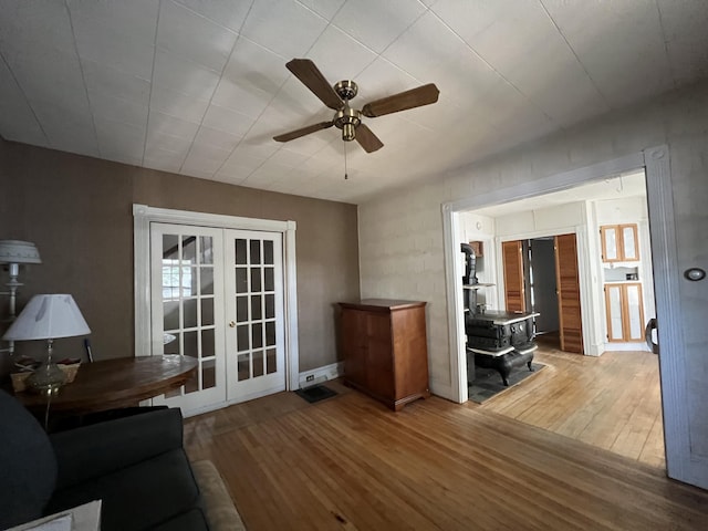 living room featuring ceiling fan, hardwood / wood-style floors, and french doors