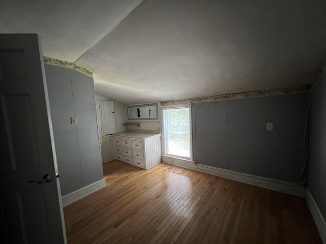 interior space with light hardwood / wood-style floors and vaulted ceiling