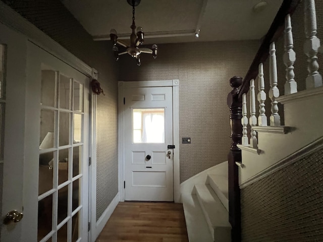 doorway featuring wood-type flooring and a notable chandelier