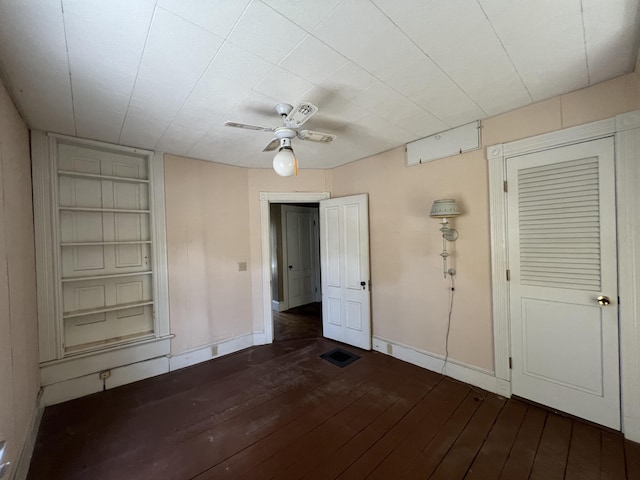 interior space featuring built in features, ceiling fan, and dark wood-type flooring