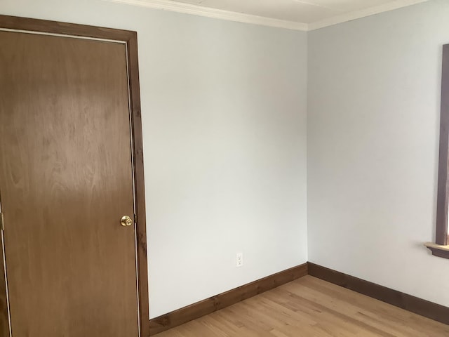 spare room featuring light hardwood / wood-style flooring and ornamental molding