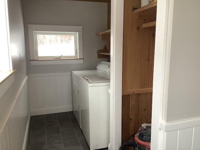 clothes washing area with dark tile patterned flooring and washer and clothes dryer