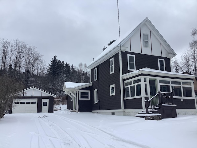 view of snow covered exterior with an outdoor structure and a garage