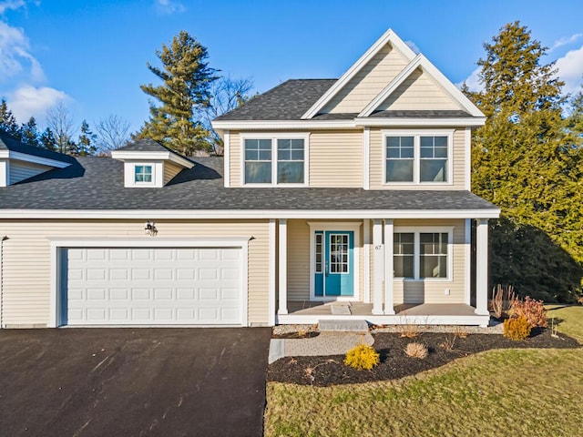 view of front of property with a garage, covered porch, a shingled roof, and aphalt driveway