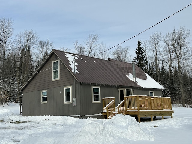 snow covered house featuring a deck