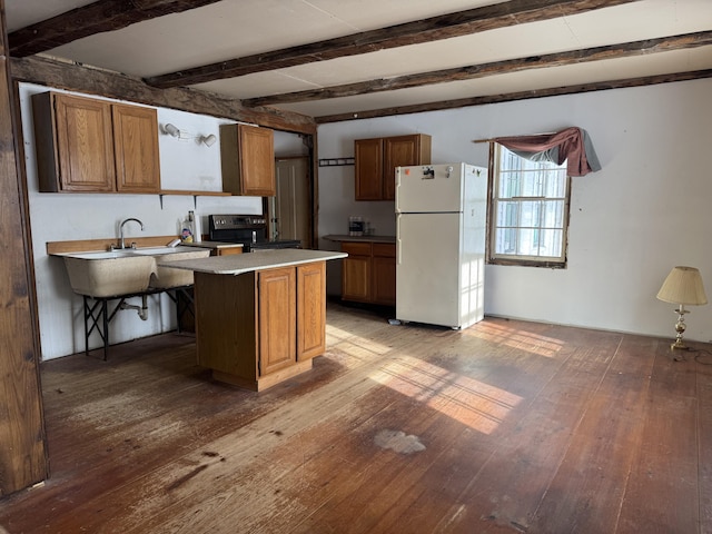 kitchen with light hardwood / wood-style flooring, a kitchen bar, kitchen peninsula, beamed ceiling, and white fridge