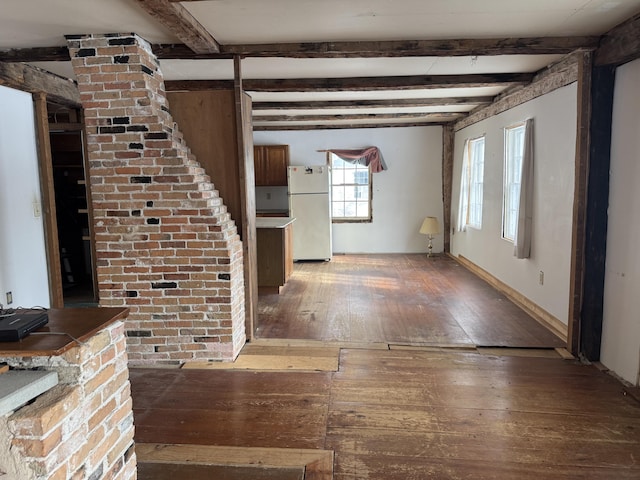 unfurnished living room featuring beam ceiling and hardwood / wood-style floors