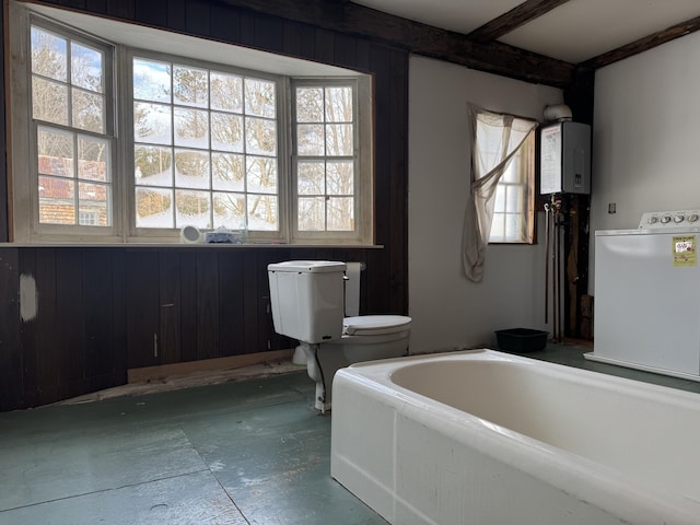 bathroom featuring beamed ceiling, tankless water heater, washer / clothes dryer, and a washtub